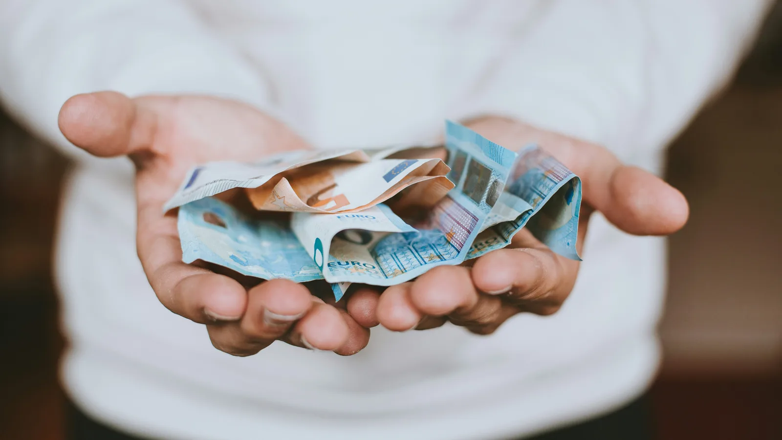 Geöffnete Hände mit Euro-Banknoten